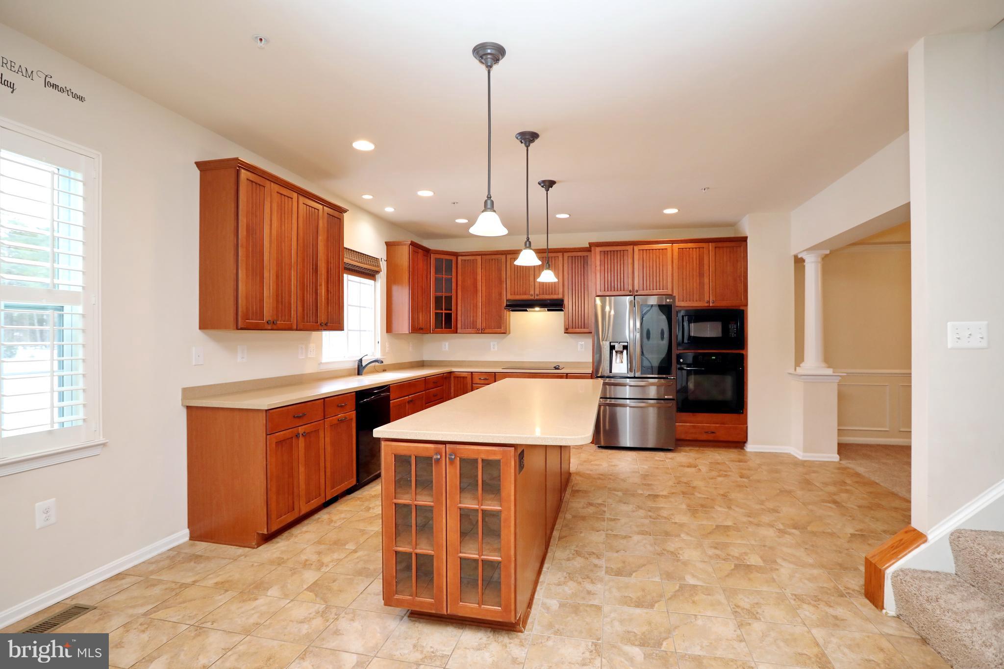 7580 Knotting Hill Lane Port Tobacco, MD 20677 - Photo 11 of 30 a kitchen with stainless steel appliances kitchen island granite countertop a sink a stove and a wooden floors