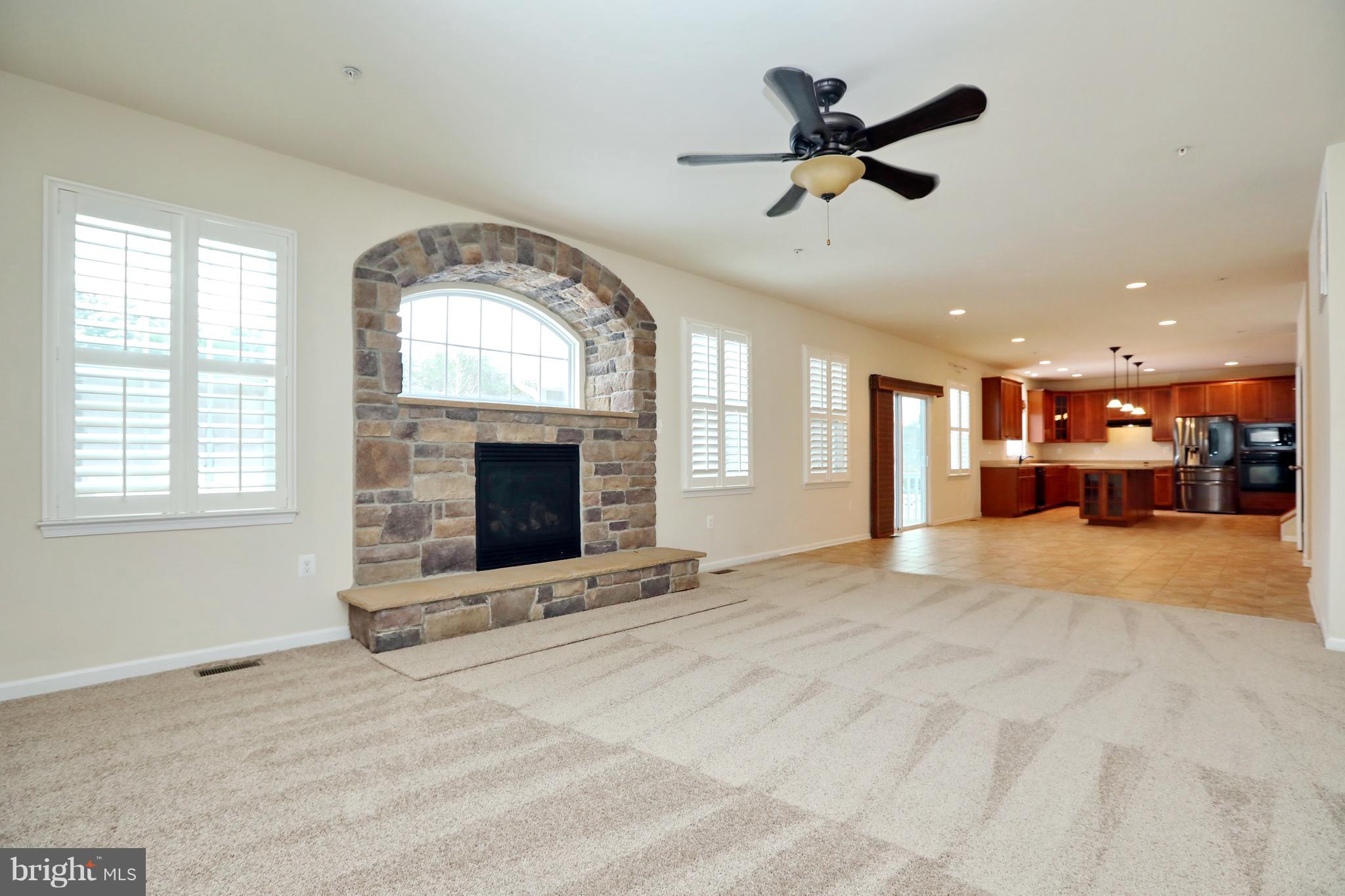 7580 Knotting Hill Lane Port Tobacco, MD 20677 - Photo 14 of 30 a view of a livingroom with a fireplace a ceiling fan and windows
