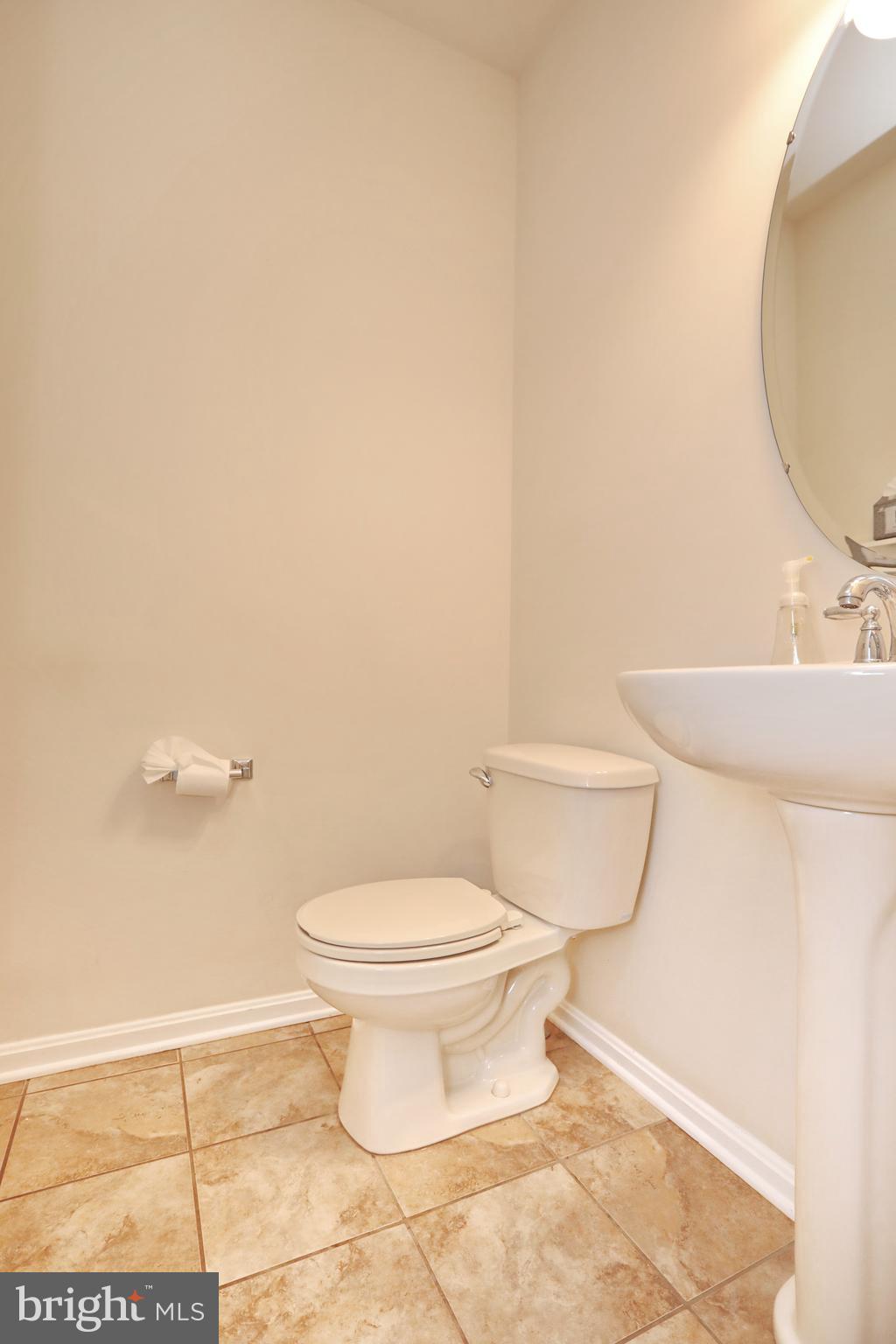 7580 Knotting Hill Lane Port Tobacco, MD 20677 - Photo 15 of 30 a white toilet sitting next to a bathroom sink and a mirror