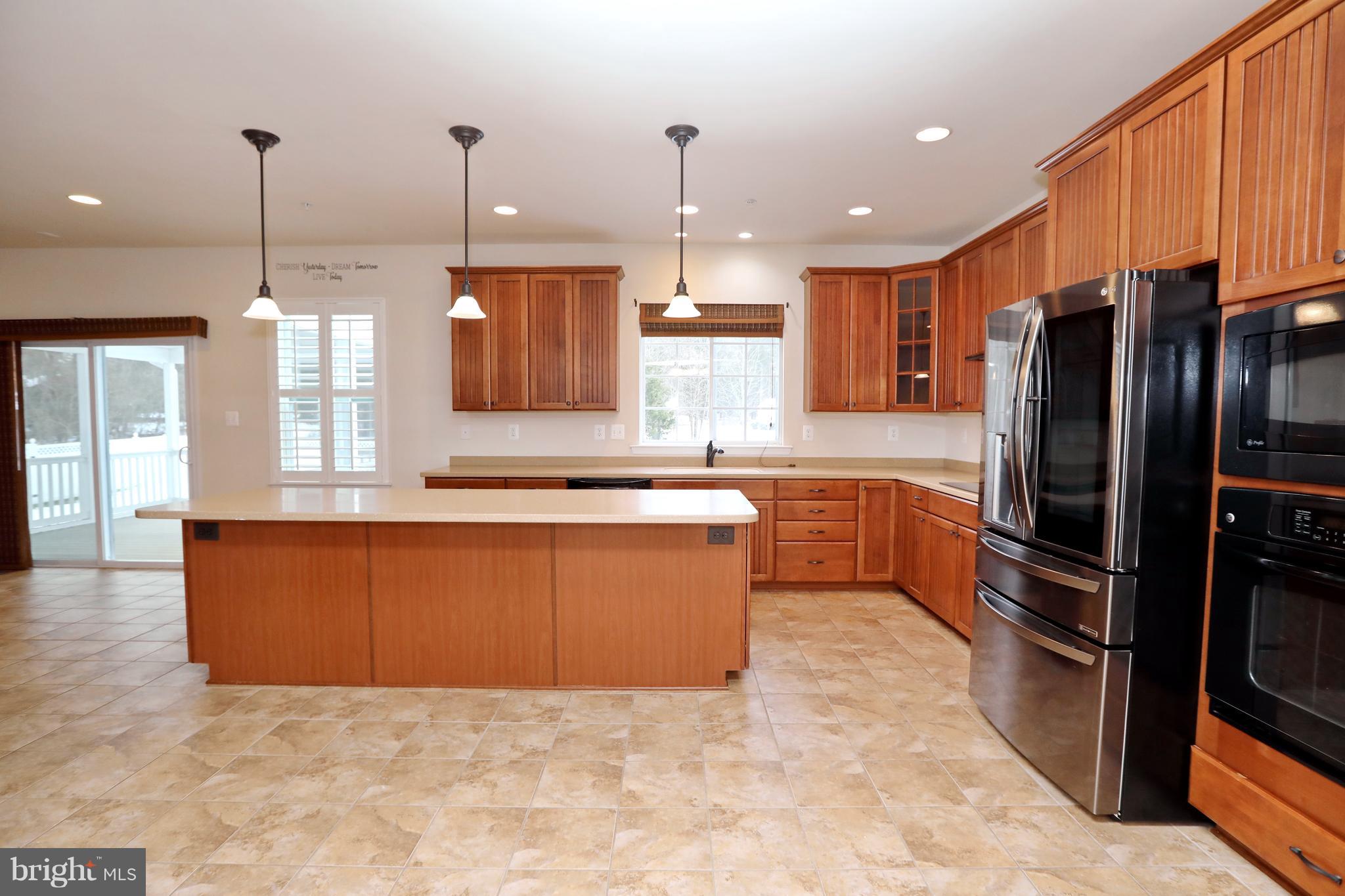 7580 Knotting Hill Lane Port Tobacco, MD 20677 - Photo 10 of 30 a large kitchen with kitchen island a large counter top stainless steel appliances and cabinets
