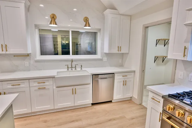 a kitchen with white cabinets and sink