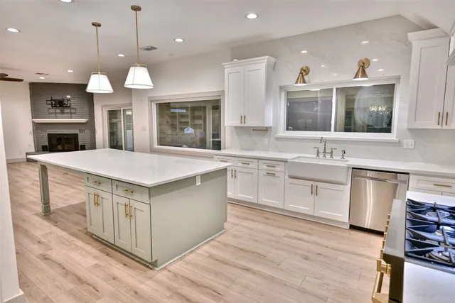 a kitchen with stainless steel appliances granite countertop a stove a sink and a refrigerator