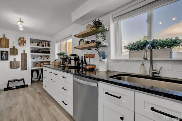 a kitchen with granite countertop a sink and cabinets