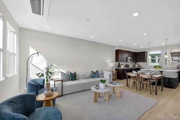 a living room with furniture a rug and a dining table