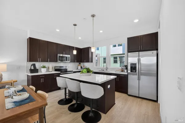 a kitchen with stainless steel appliances granite countertop a sink refrigerator and cabinets