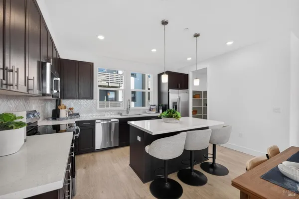 a kitchen with kitchen island granite countertop wooden cabinets and stainless steel appliances