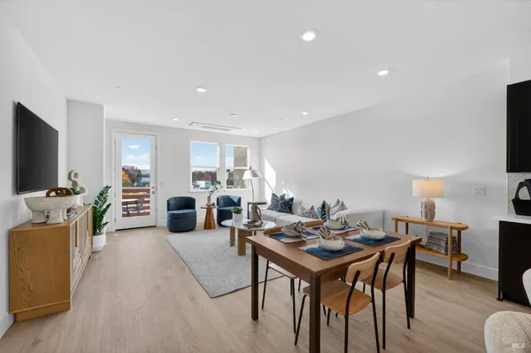 a living room with furniture a flat screen tv and a table