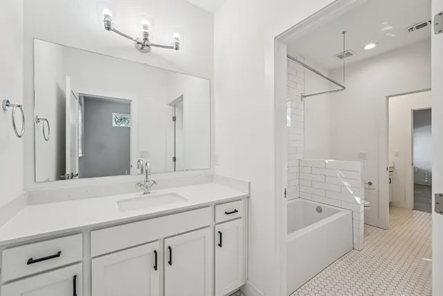 a bathroom with a tub sink shower and mirror