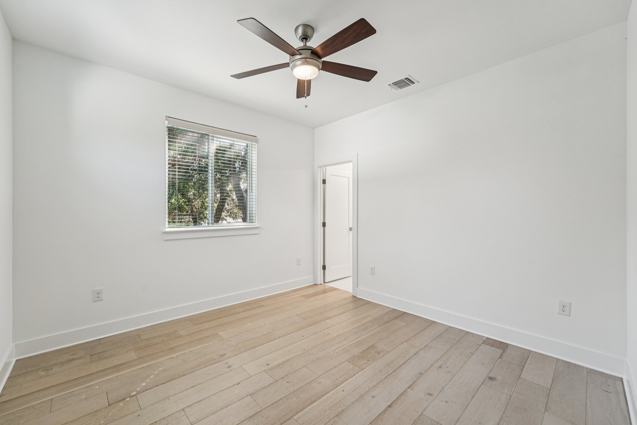 739 Gunter Street, Unit 1 Austin, TX 78702 - Photo 21 of 26 an empty room with wooden floor and ceiling fan