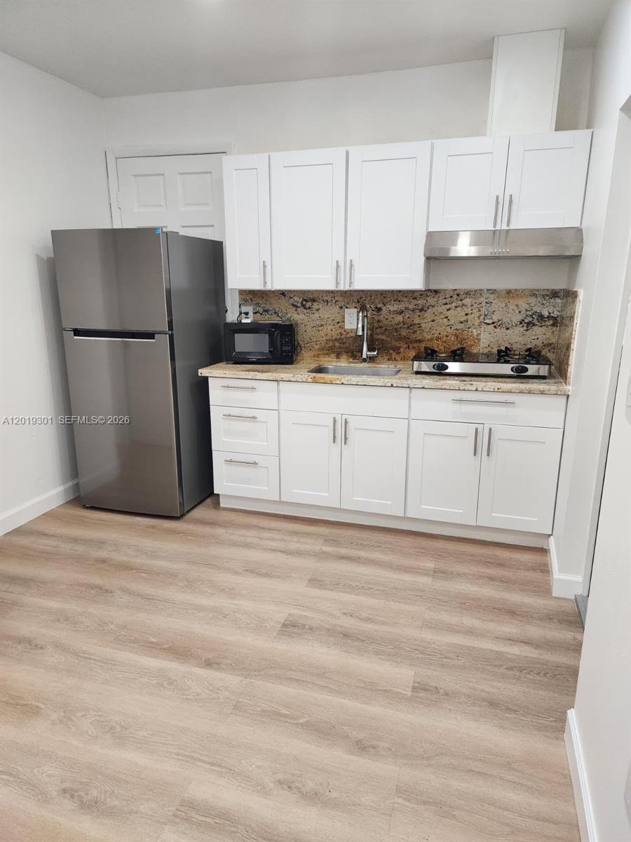 25948 Southwest 132nd Avenue, Unit 1 Homestead, FL 33032 - Photo 1 of 6 a kitchen with a refrigerator and a stove