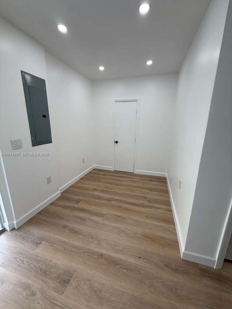 25948 Southwest 132nd Avenue, Unit 1 Homestead, FL 33032 - Photo 2 of 6 an empty room with wooden floor and white walls