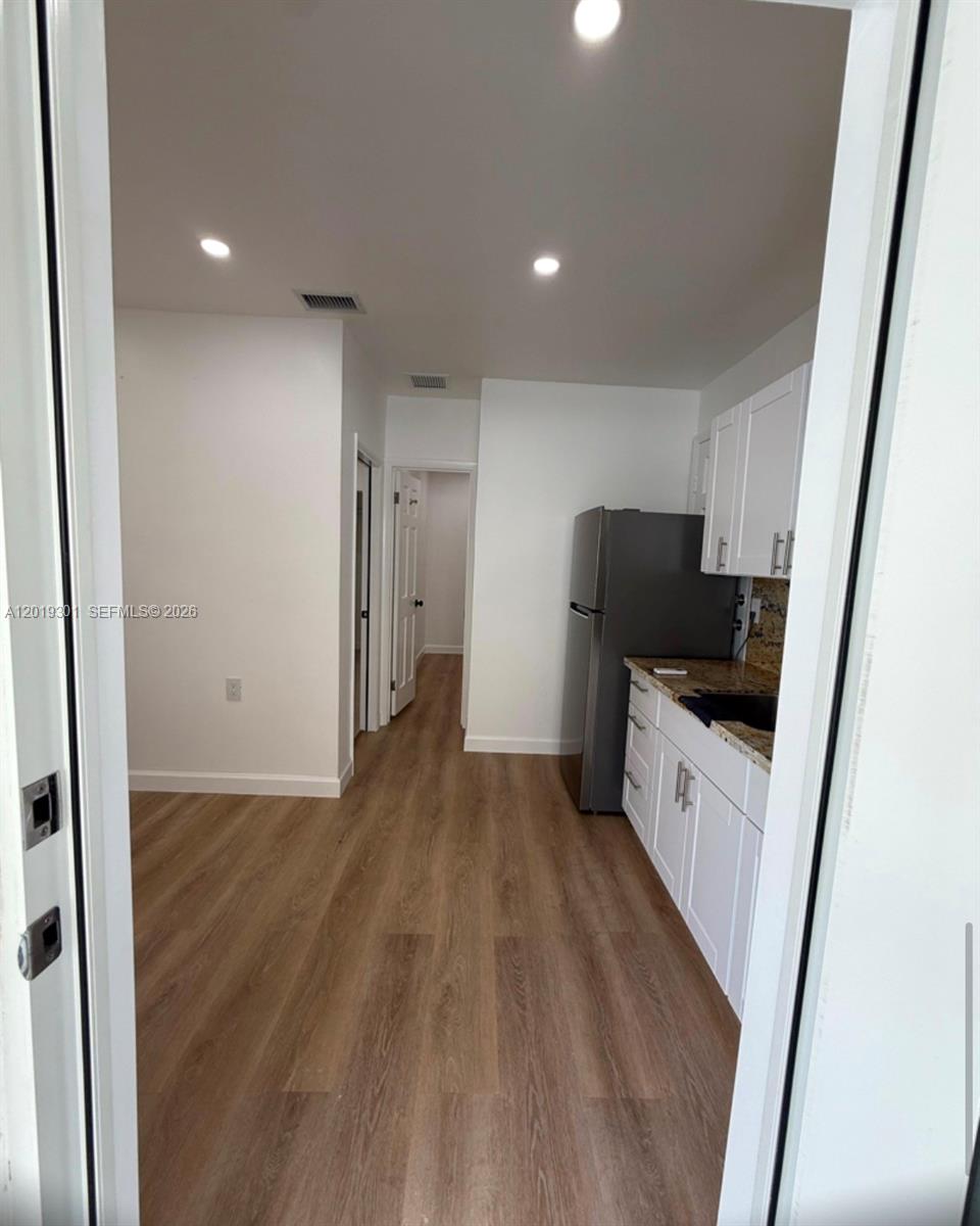 25948 Southwest 132nd Avenue, Unit 1 Homestead, FL 33032 - Photo 3 of 6 a view of kitchen with refrigerator sink and wooden floor