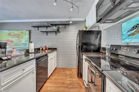 a kitchen with stainless steel appliances granite countertop sink stove top oven and cabinets