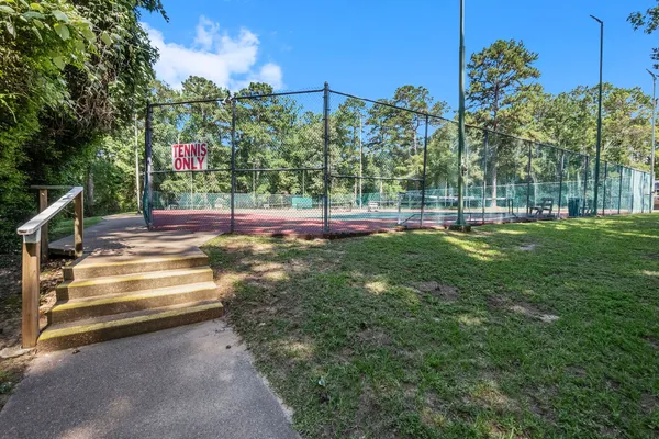 a view of a garden with a bench in front of the house