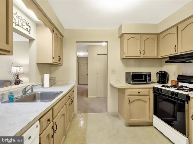 a kitchen with cabinets appliances a sink and a counter top space