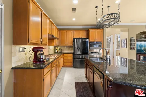 a kitchen with stainless steel appliances granite countertop a sink a stove and a refrigerator