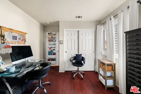 a view of a workspace with furniture and a window