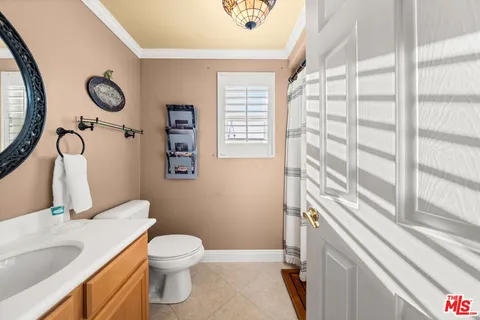 a bathroom with a granite countertop sink toilet and a mirror