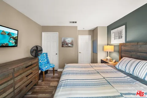 a bedroom with a bed and painting on the wall