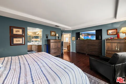 a bedroom with a bed and a television