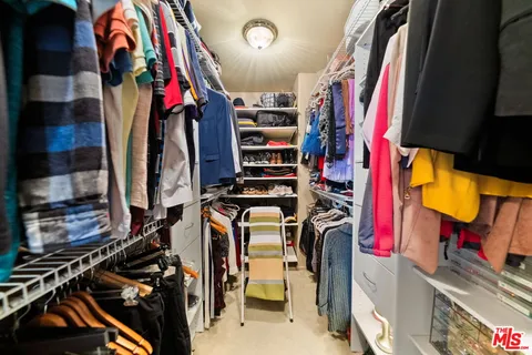 a view of walk in closet with clothes