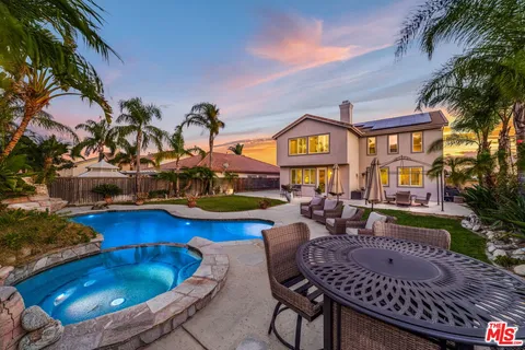 a view of a house with backyard swimming pool and sitting area