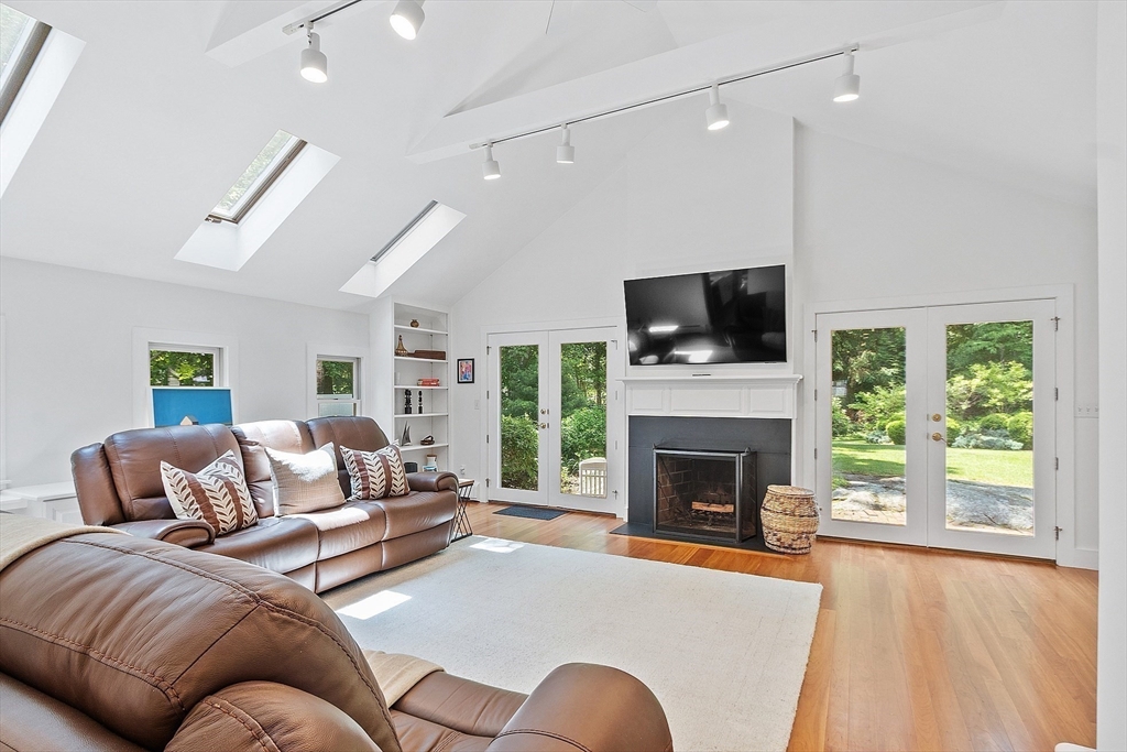8 Piper Road Acton, MA 01720 - Photo 24 of 42 a living room with furniture a fireplace and a flat screen tv