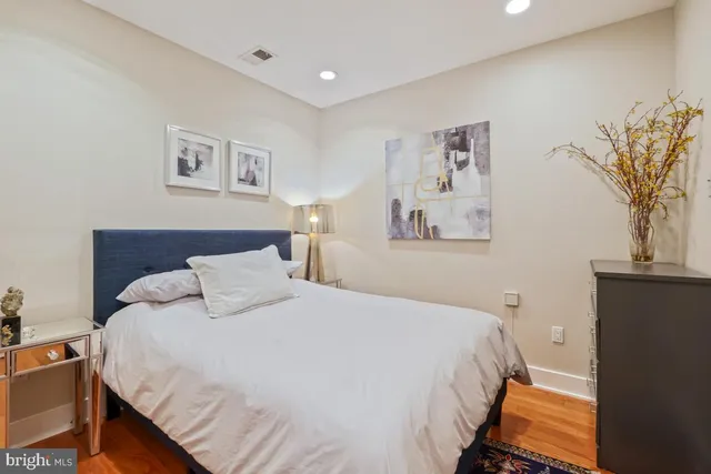 a bedroom with a bed and a painting on the wall