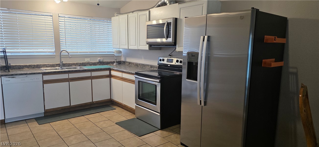 Tiled flooring and white cabinetry define this functional kitchen workspace.