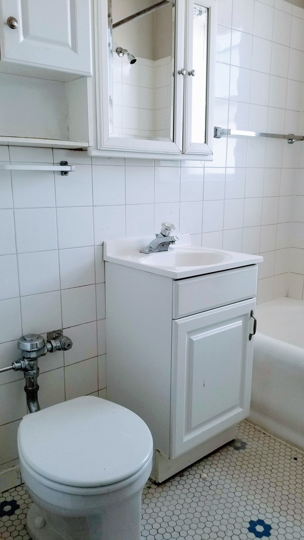 4764 North Virginia Avenue, Unit 306 Chicago, IL 60625 - Photo 16 of 16 a bathroom with a sink toilet and mirror