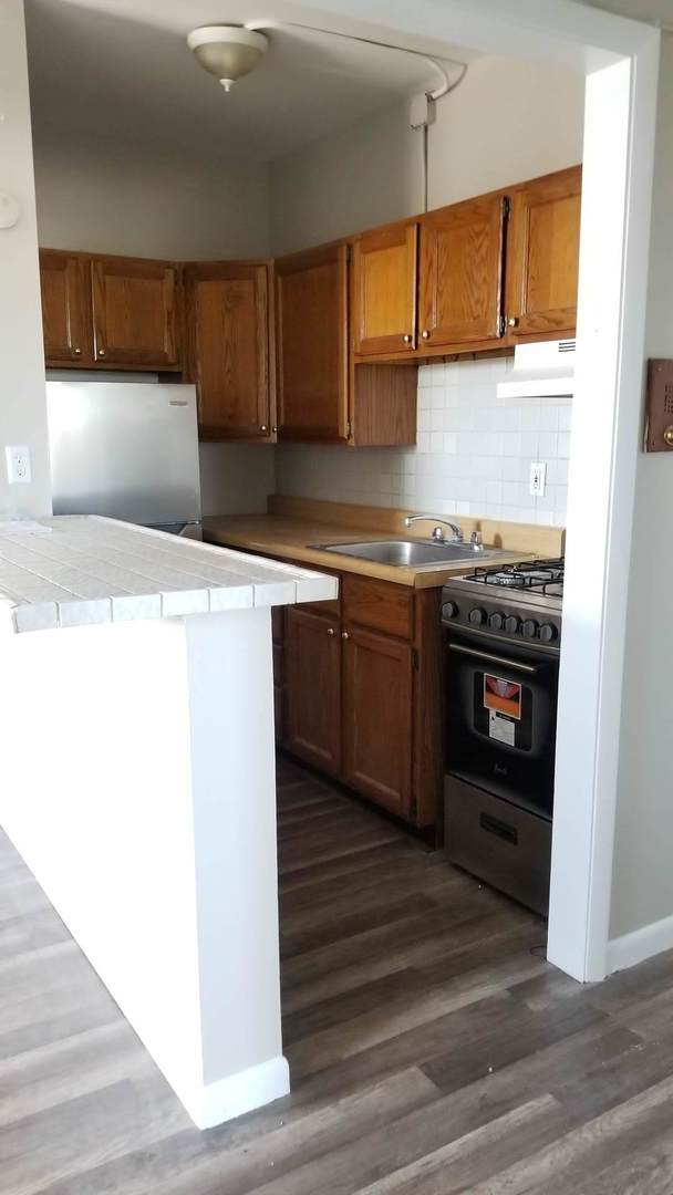 4764 North Virginia Avenue, Unit 306 Chicago, IL 60625 - Photo 4 of 16 a kitchen with stainless steel appliances granite countertop a sink and a stove