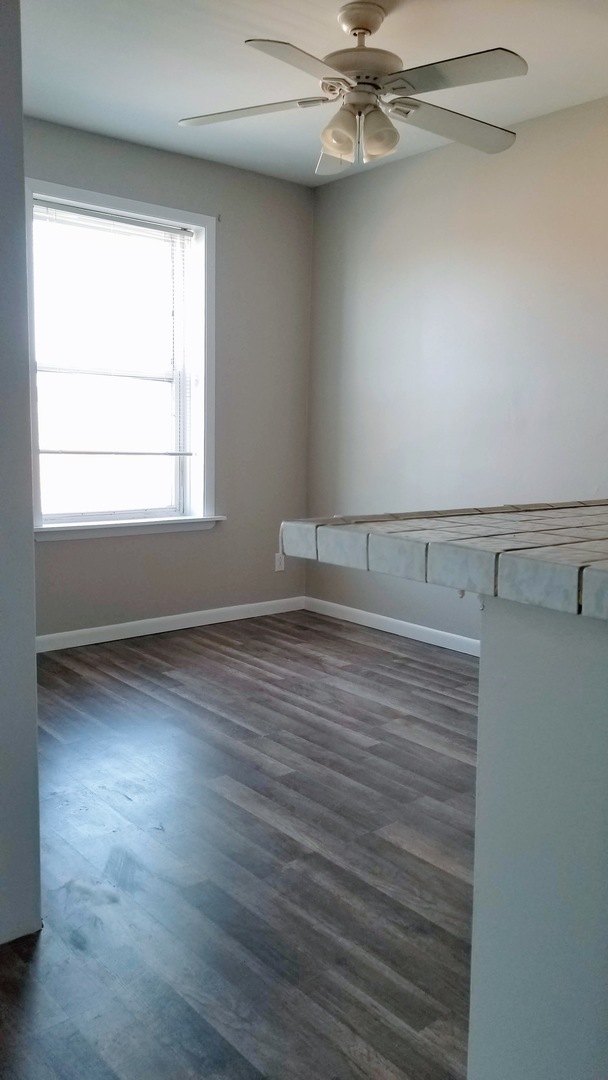 4764 North Virginia Avenue, Unit 306 Chicago, IL 60625 - Photo 5 of 16 an empty room with wooden floor fan and windows