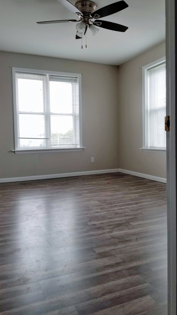 4764 North Virginia Avenue, Unit 306 Chicago, IL 60625 - Photo 6 of 16 an empty room with wooden floor and windows