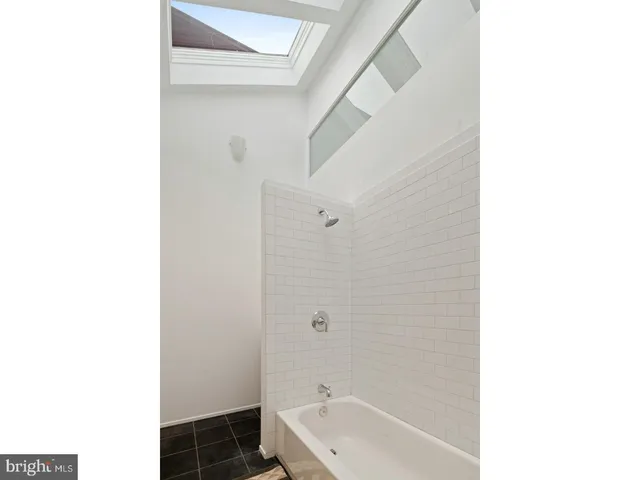 a bathroom with a tub shower and a sink