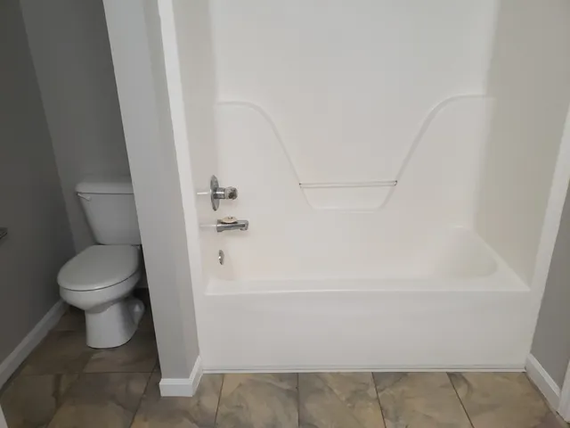 a front view of a house with a garden and trees