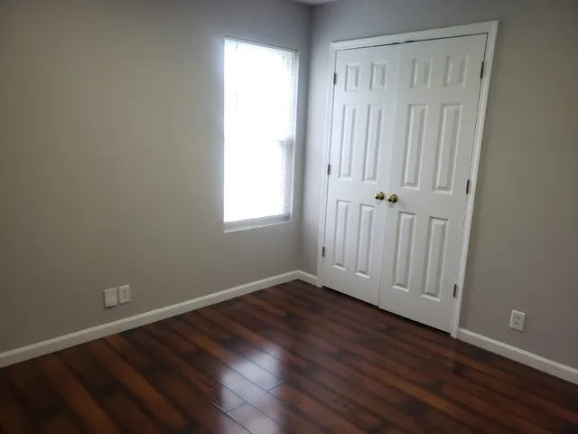 a view of an empty room with wooden floor