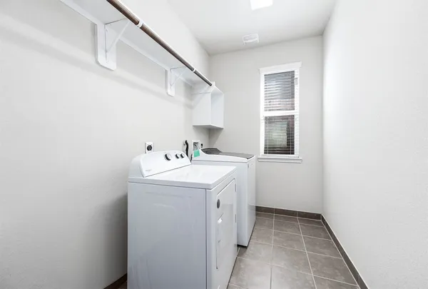a utility room with cabinets washer and dryer