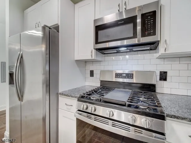 a kitchen with stainless steel appliances granite countertop a stove and a microwave