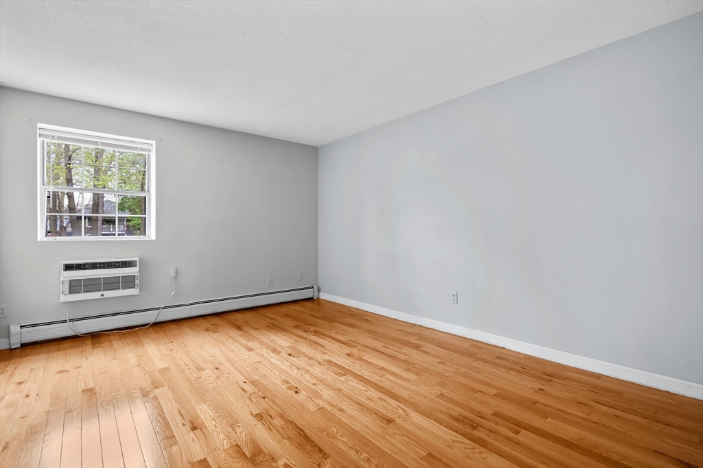 804 Centre Street, Unit 104 Boston, MA 02130 - Photo 12 of 32 a view of an empty room with wooden floor and a window