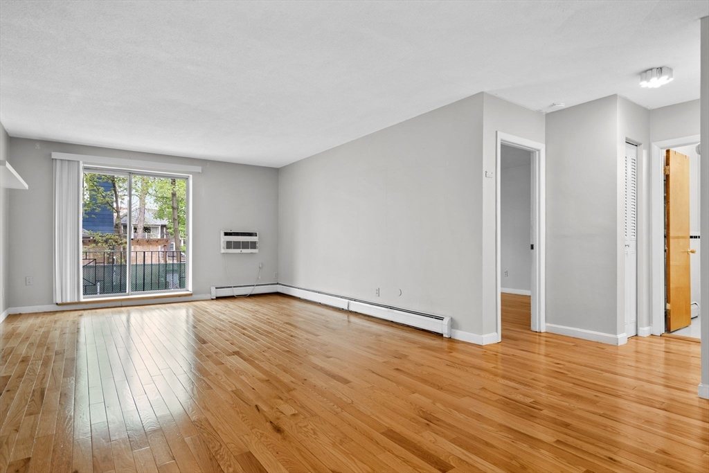 804 Centre Street, Unit 104 Boston, MA 02130 - Photo 13 of 32 a view of an empty room with wooden floor and a window