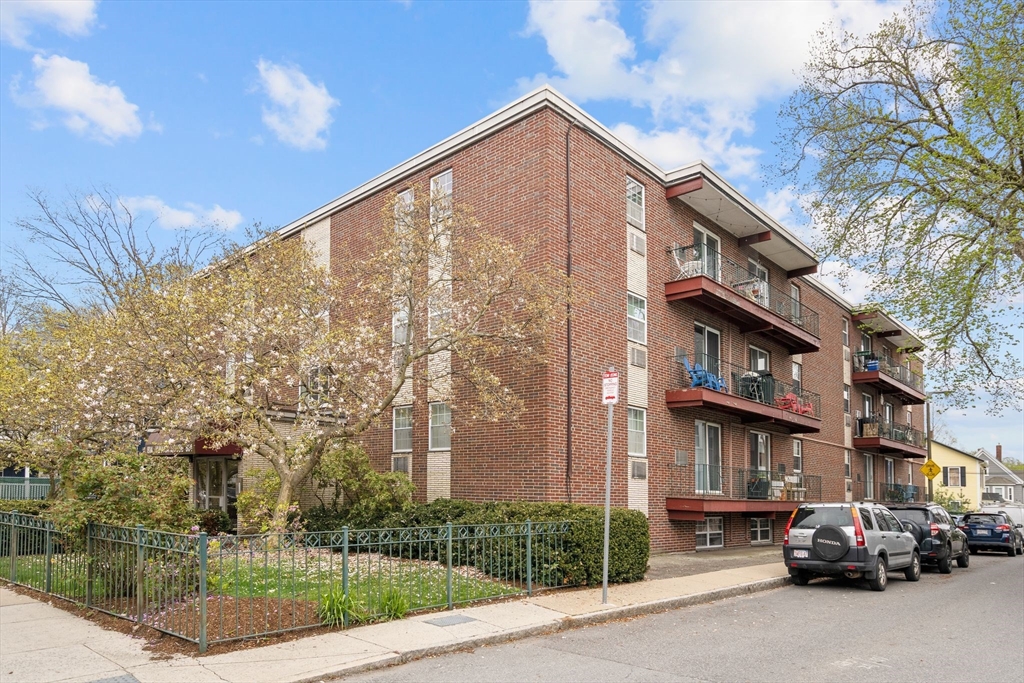 804 Centre Street, Unit 104 Boston, MA 02130 - Photo 31 of 32 a city street lined with parked cars front of buildings