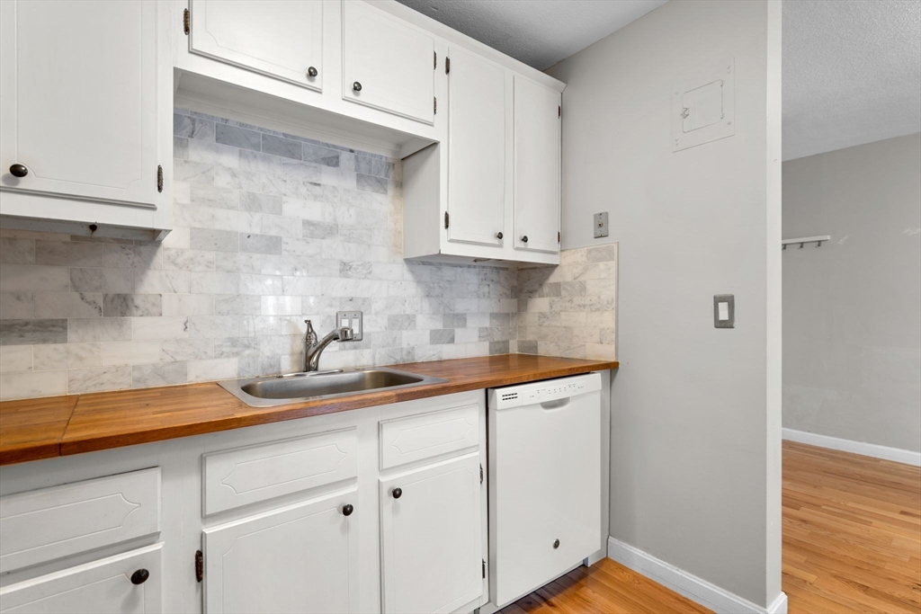 804 Centre Street, Unit 104 Boston, MA 02130 - Photo 5 of 32 a kitchen with granite countertop white cabinets and a sink