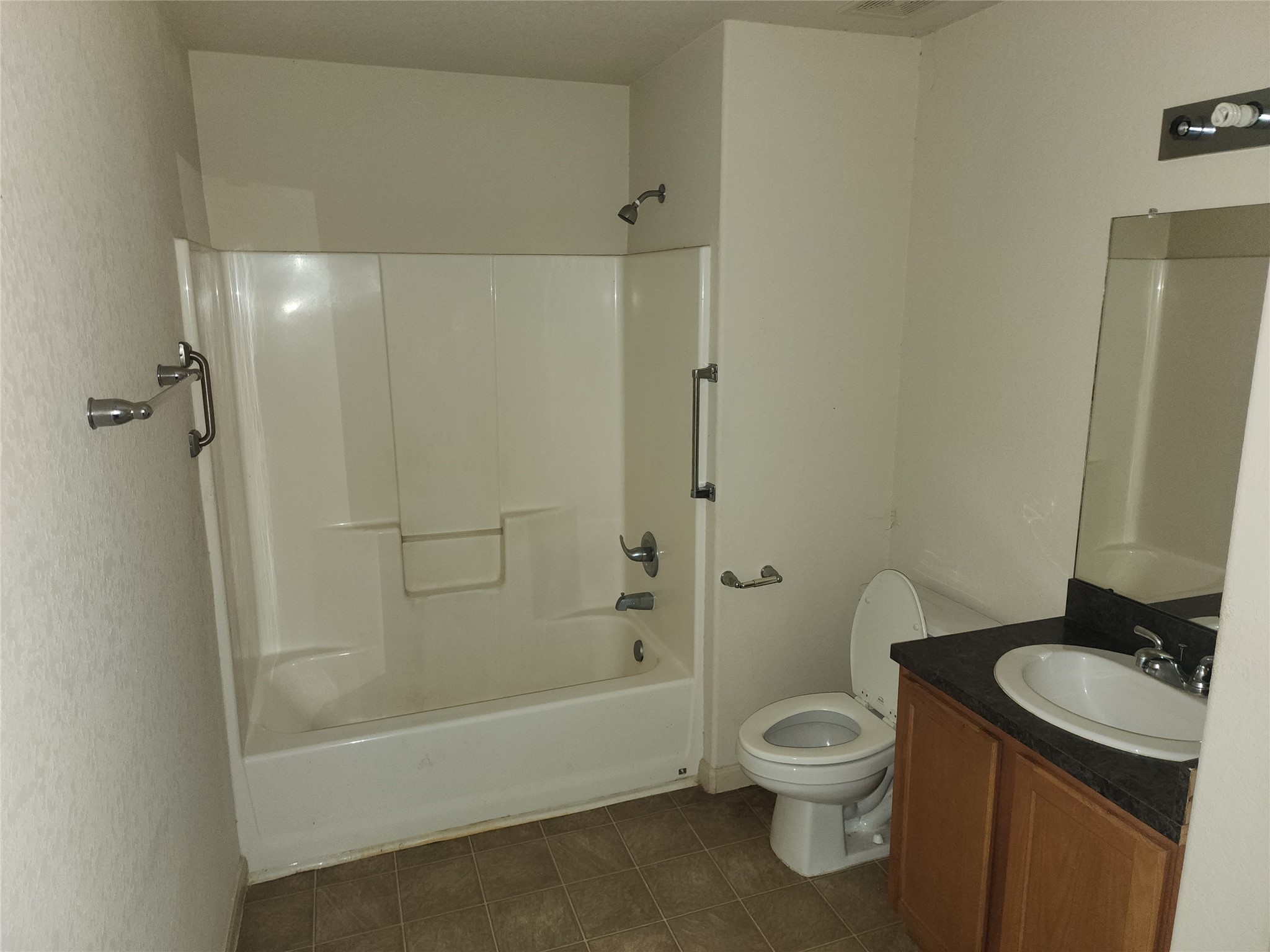 315 20th Street Dickinson, TX 77539 - Photo 18 of 19 a bathroom with a granite countertop toilet a sink and a bathtub