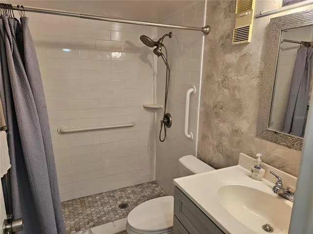 a bathroom with a shower a toilet and a sink