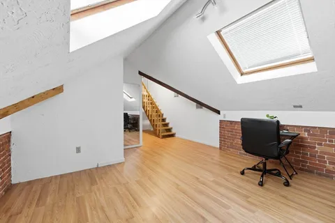 a view of a workspace with wooden floor and chair