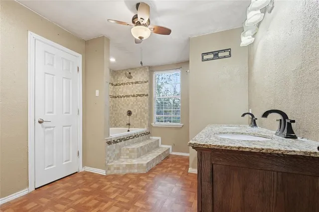 a spacious bathroom with a granite countertop sink a mirror and shower