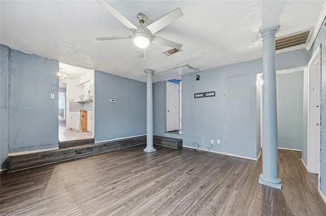 an empty room with wooden floor and window