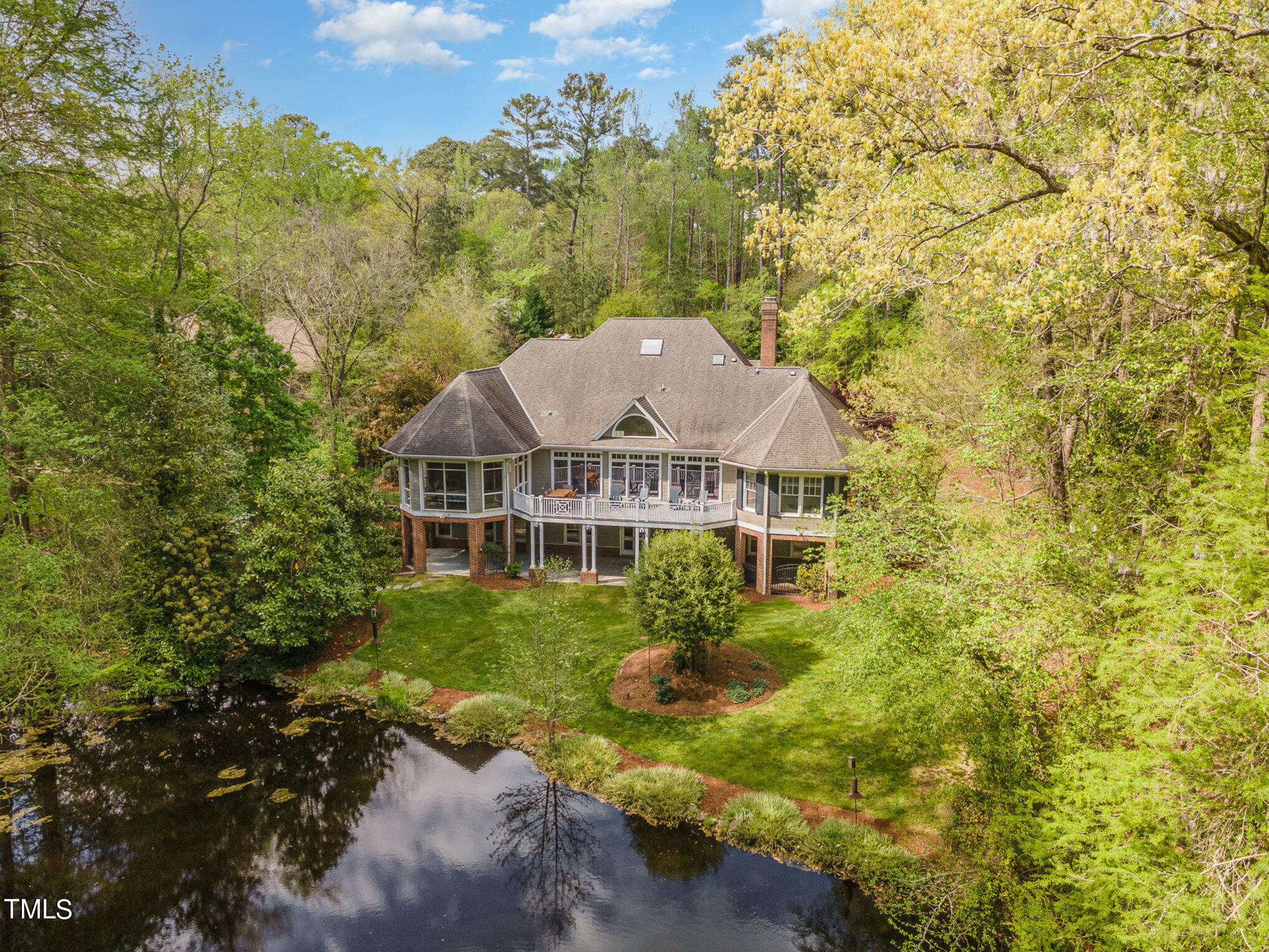 a view of a house with a big yard and large trees