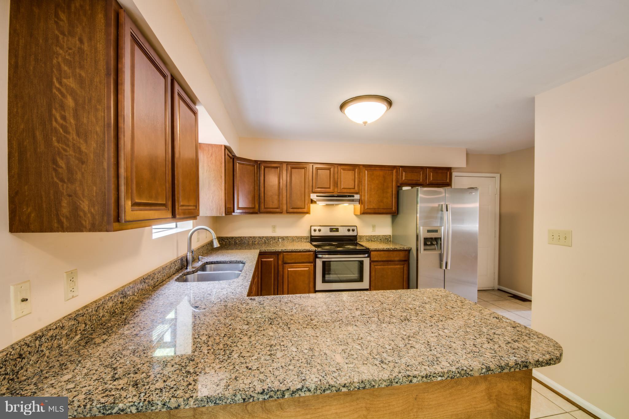 414 Ferry Road Fredericksburg, VA 22405 - Photo 6 of 28 a kitchen with stainless steel appliances granite countertop a sink stove and refrigerator
