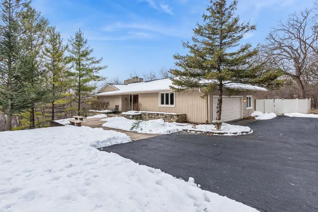 a view of a house with snow and a tree